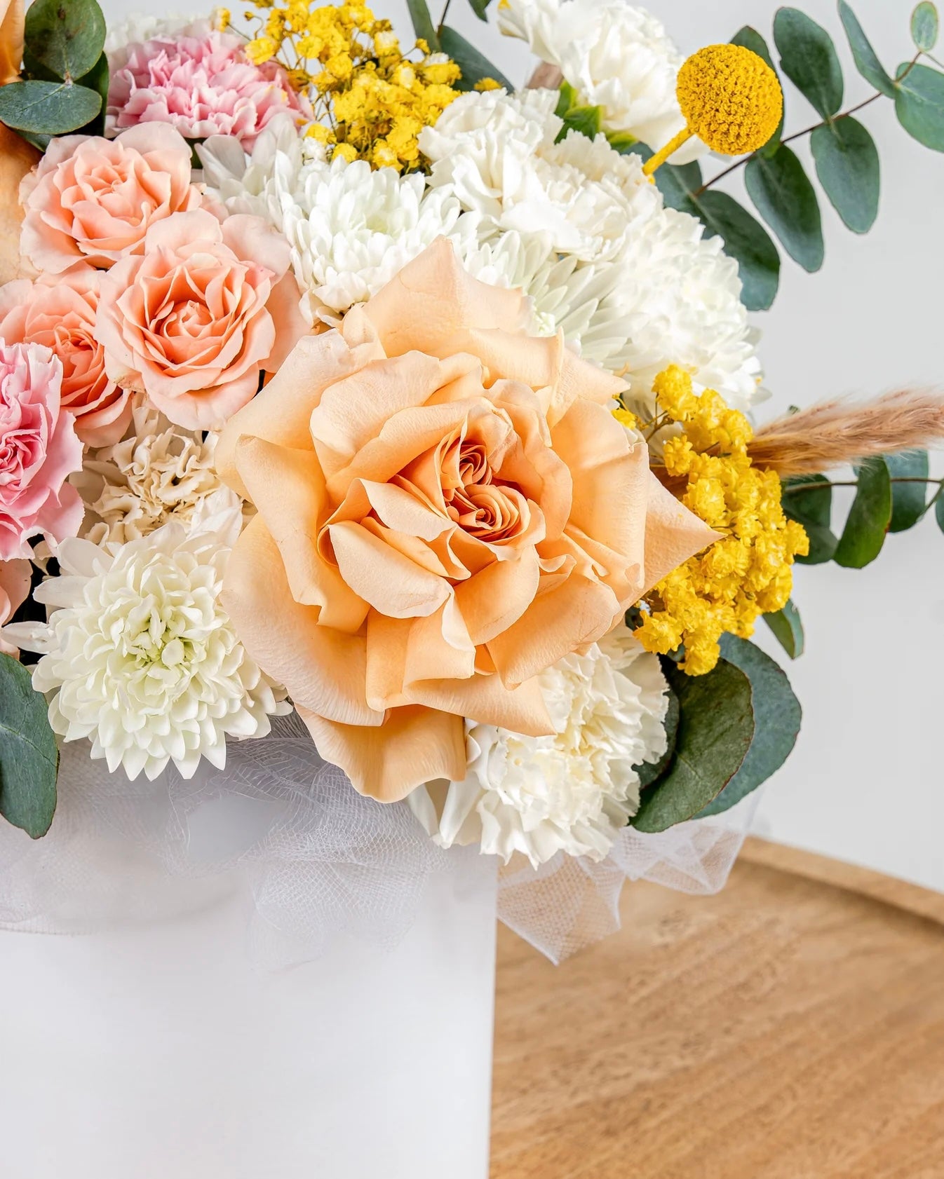 Aranjament floral pastel in cutie alba – trandafiri peach, flori delicate si accente naturale