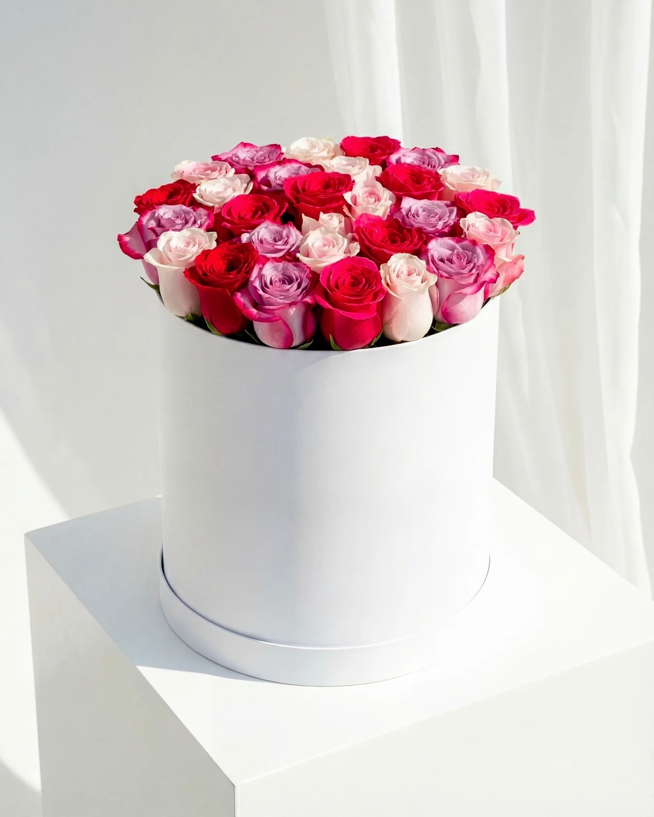 Cutie cu trandafiri mix in nuante de rosu, roz si lila – aranjament floral premium elegant