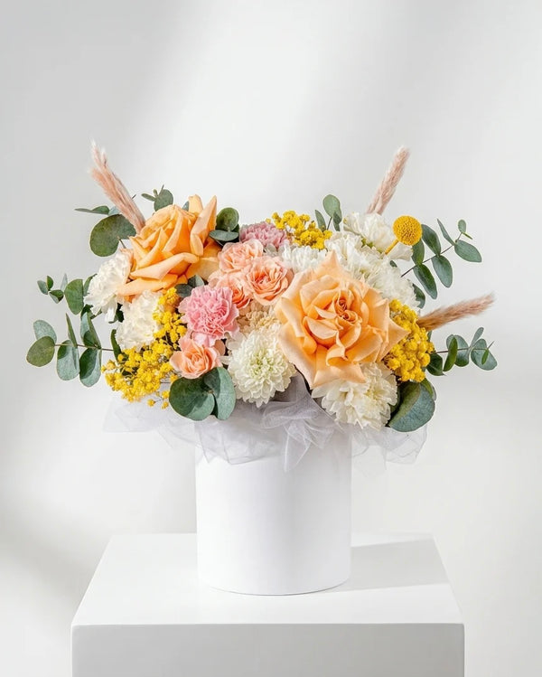 Aranjament floral pastel in cutie alba – trandafiri peach, flori delicate si accente naturale